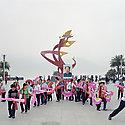 Crowd of people marching with fans and banners.